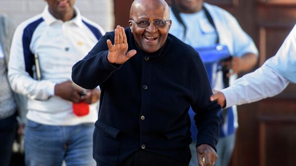 In this Monday May 6, 2019. file photo Anglican Archbishop Emeritus Desmond Tutu exits his home in Cape Town, South Africa. As South Africa’s anti-apartheid icon Archbishop Desmond Tutu turns 90, recent racist graffiti on a portrait of the Nobel winner highlights the continuing relevance of his work for equality. Often hailed as the conscience of South Africa, Tutu was a key campaigner against South Africa’s previous brutal system of oppression against the Black majority.  - Sputnik International