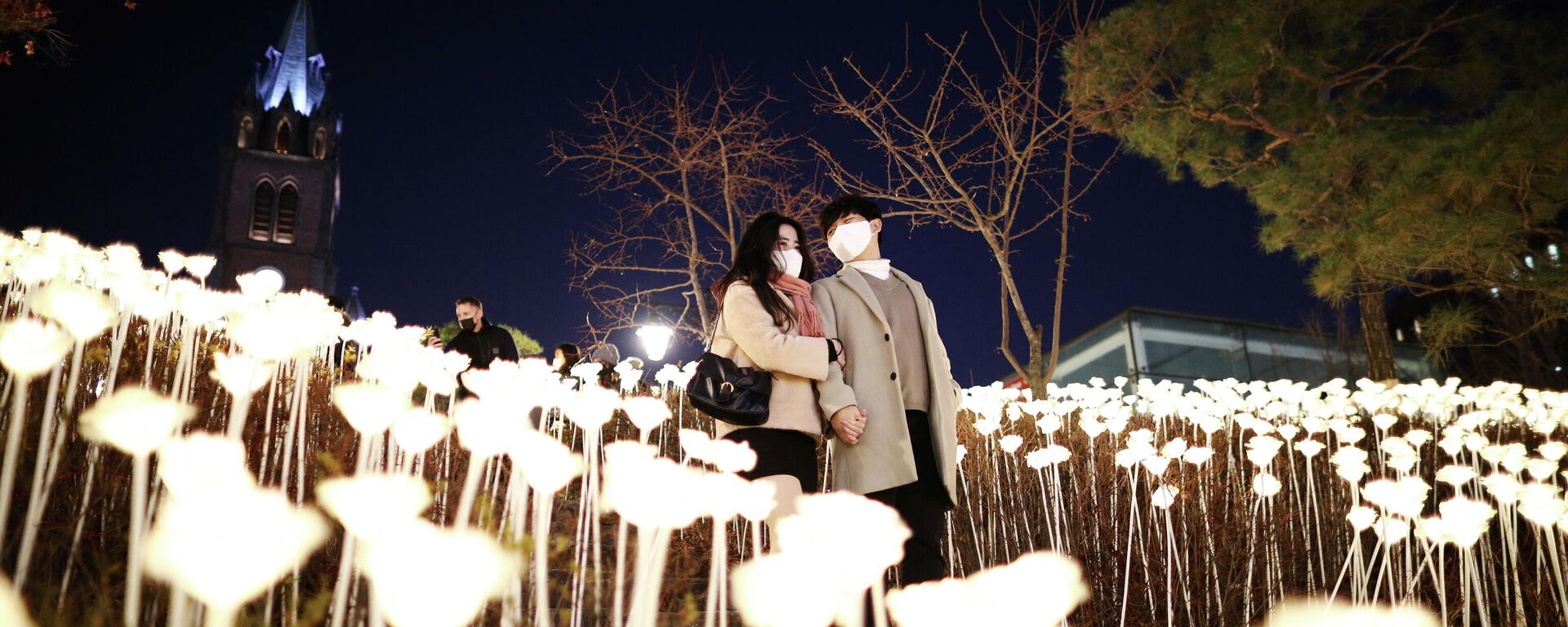 A couple wearing masks to prevent contracting the coronavirus disease (COVID-19) enjoys a Christmas illumination at Myeongdong Cathedral in Seoul, South Korea, December 23, 2021 - Sputnik International, 1920, 27.12.2021