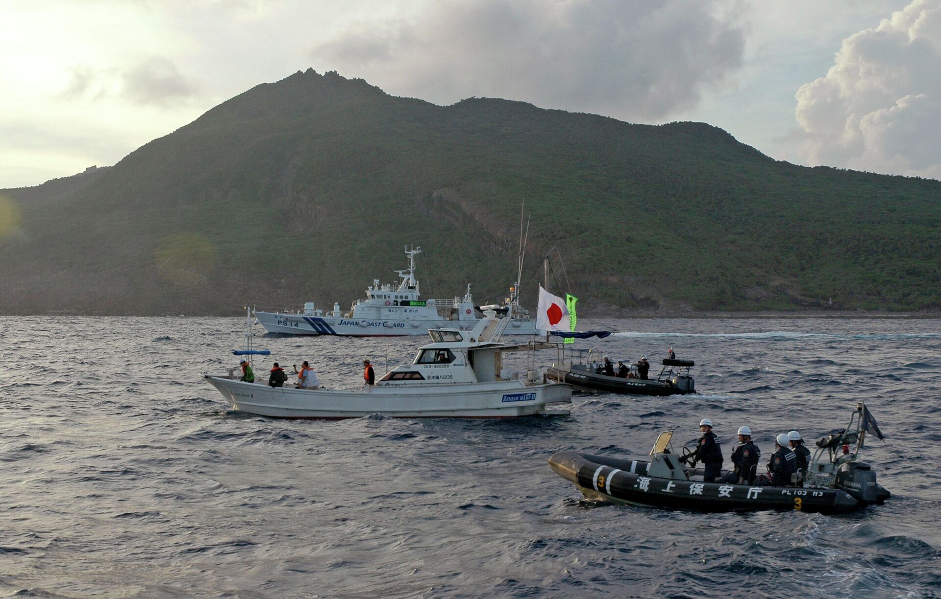A Japanese Coast Guard boat and vessel sail alongside Japanese activists' fishing boat, not in photo, warning the activists away from a group of disputed islands called Senkaku by Japan and Diaoyu by China on Aug. 18, 2013 - Sputnik International, 1920, 22.02.2023