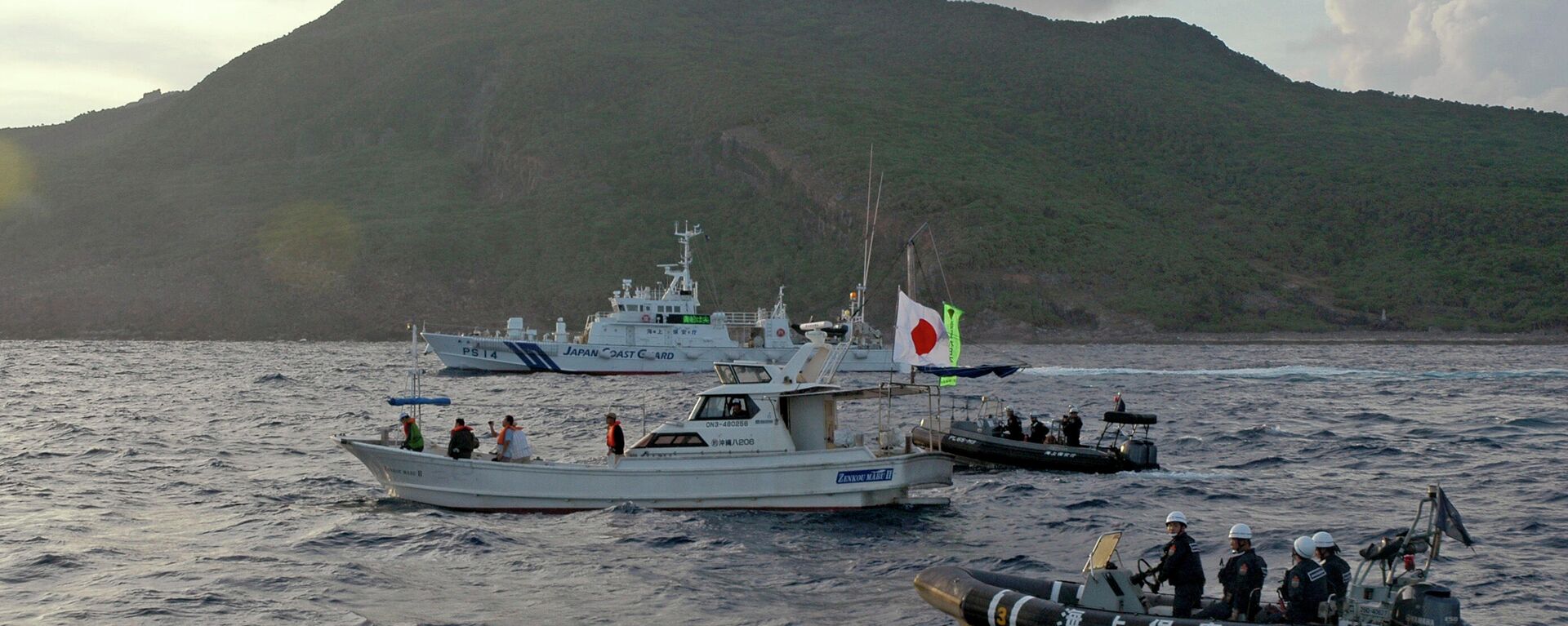 A Japanese Coast Guard boat and vessel sail alongside Japanese activists' fishing boat, not in photo, warning the activists away from a group of disputed islands called Senkaku by Japan and Diaoyu by China on Aug. 18, 2013 - Sputnik International, 1920, 17.10.2023