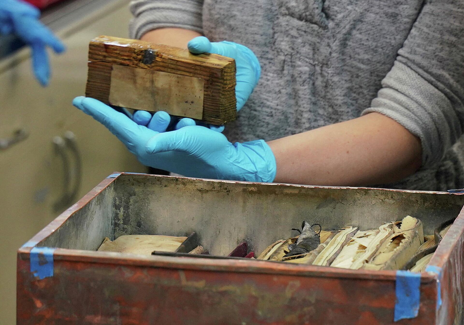 Sue Donovan, conservator for Special Collections of the University of Virginia Library, removes a piece of wood with a bullet found in a time capsule recovered from Confederate General Robert E. Lee's monument in Richmond, Virginia, U.S., December 28, 2021. - Sputnik International, 1920, 29.12.2021