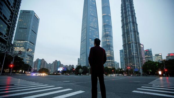 A man stands at a crossroads in Lujiazui financial district in Pudong, Shanghai, on the day of the opening session of the National People's Congress (NPC), China March 5, 2021 - Sputnik International