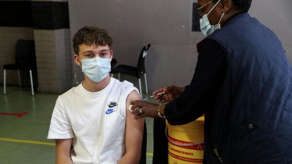 FILE PHOTO: A healthcare worker administers a dose of the Pfizer coronavirus disease (COVID-19) vaccine to a teenager, amidst the spread of the SARS-CoV-2 variant Omicron, in Johannesburg - Sputnik International