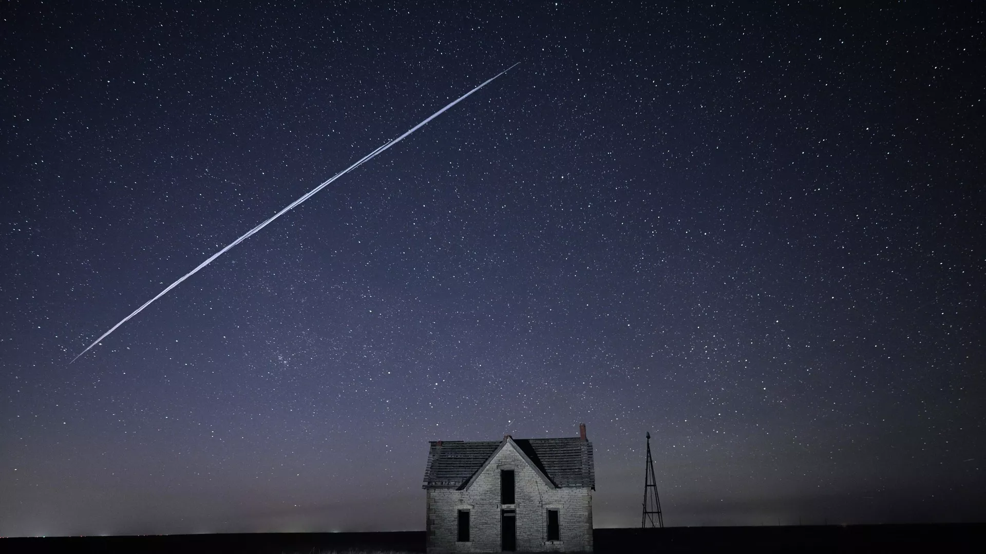 Na tym zdjęciu wykonanym z długą ekspozycją sznur satelitów SpaceX StarLink przechodzi nad starym kamiennym domem w pobliżu Florence, Kansas, w czwartek, 6 maja 2021 r. - Sputnik International, 1920, 02.10.2023