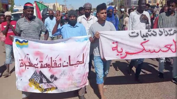 Protesters opposed to military rule carry banners as they march in Khartoum North, Sudan December 30, 2021 in this screengrab obtained from a social media video. - Sputnik International