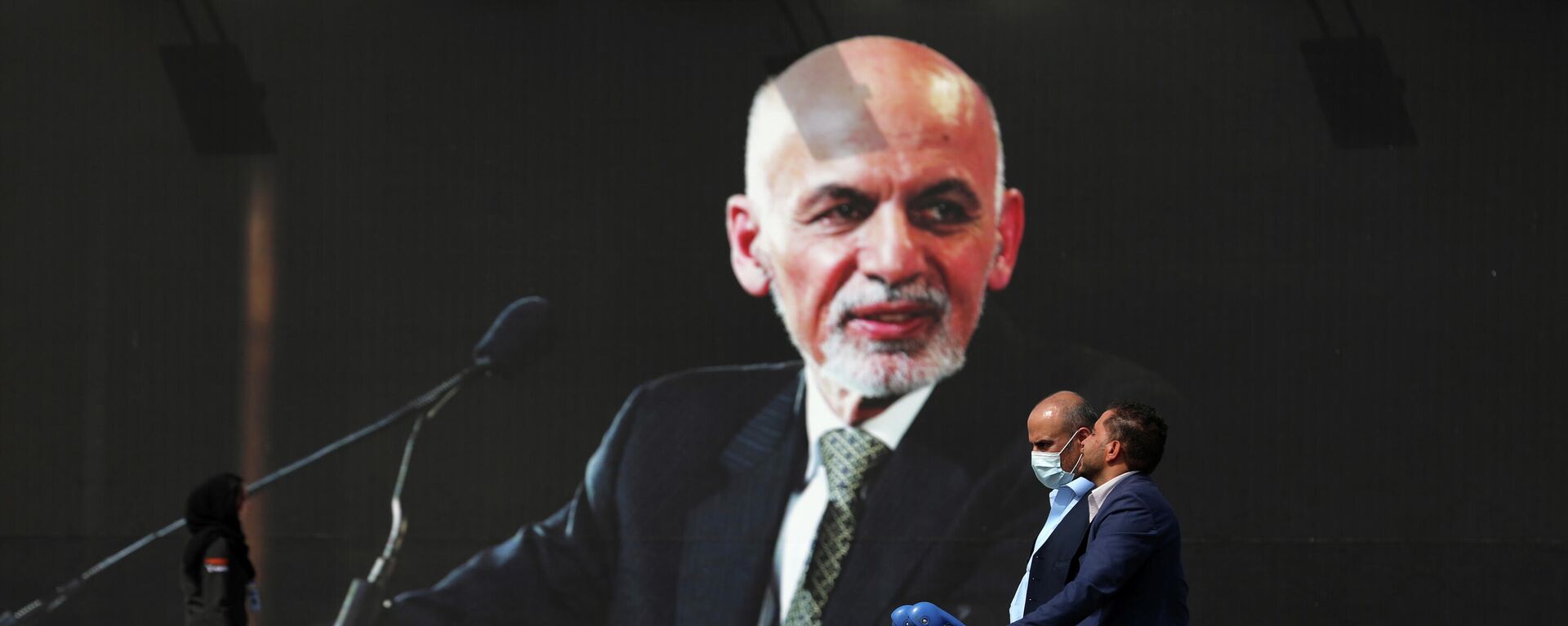 Passengers walk to the departures terminal of Hamid Karzai International Airport in Kabul, Afghanistan, on Saturday, Aug. 14, 2021, past a mural of President Ashraf Ghani, as the Taliban offensive encircled the capital.  - Sputnik International, 1920, 27.12.2022