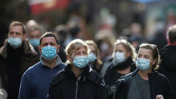 People, wearing protective face masks, walk on the Mouffetard street, amid the spread of the coronavirus disease (COVID-19) pandemic, in Paris, France, December 30, 2021 - Sputnik International