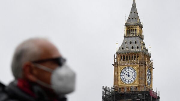 A man walks near the Big Ben, ahead of New Year's Eve events when all four faces will be visible for first time to ring in the new year since restoration works commenced in 2017 at the Houses of Parliament, in London - Sputnik International