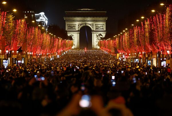 People attend New Year celebrations on the Champs-Elysees in Paris, France as the traditional light show and fireworks have been cancelled due to the spread of the coronavirus disease (COVID-19), 31 December 2021. - Sputnik International