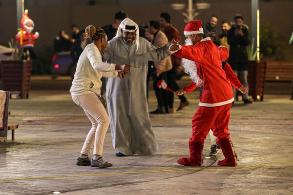 People, including a man dressed in a Santa Claus costume, dance as they celebrate the New Year in Basra, Iraq, Friday, 31 December 2021.  - Sputnik International