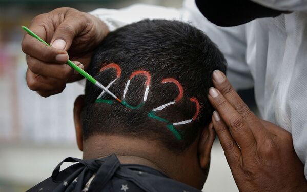 A barber colours the digits of the number 2022 after cutting a man&#x27;s hair to welcome the upcoming new year, at a barbershop in Ahmedabad, India, 31 December 2021. - Sputnik International