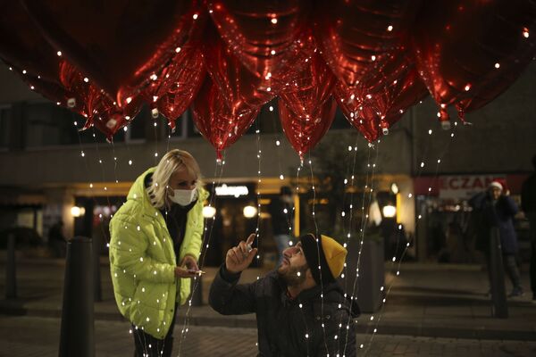 A balloon seller talks to a client in Ortakoy during New Year's Eve celebrations in Istanbul, Turkey, Friday, 31 December 2021.  - Sputnik International