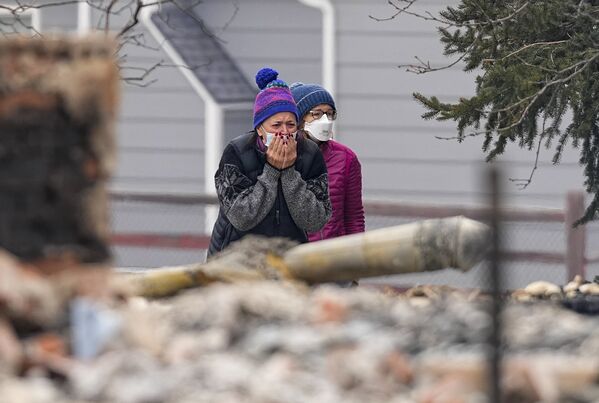 A woman cries as she sees the smouldering ruins of a home destroyed by the Marshall Wildfire in Louisville, Colorado, Friday, 31 December 2021.   - Sputnik International