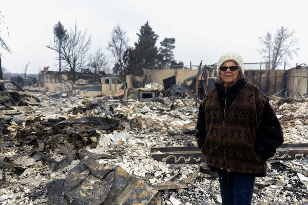 Linda Jackson stands in front of the remains of her two-story home, which was consumed during the Marshall Fire in Louisville, Colorado, 31 December 2021. - Sputnik International