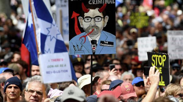 People hold up placards during a rally against Covid-19 lockdown and vaccination measures in Melbourne on 20 November 2021. - Sputnik International