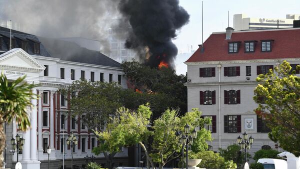A fire burns at the Houses of Parliament, in Cape Town, South Africa, Sunday, Jan. 2, 2022. The country's minister of public works and infrastructure said Sunday's fire started on the third floor of a building that houses offices and spread to the National Assembly building, where South Africa's Parliament sits. - Sputnik International