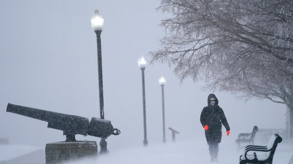 Snow blows sideways in gusty wind as Karla Rivas strolls at Federal Hill Park, Monday, Jan. 3, 2022, in Baltimore. Rivas, who is originally from Miami, said this was her first snow storm. - Sputnik International