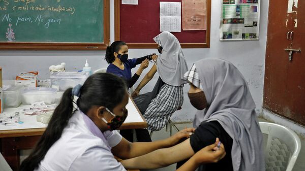 School girls receive a dose of Bharat Biotech's coronavirus disease (COVID-19) vaccine, Covaxin, during a vaccination drive for children aged 15-18 in Ahmedabad, India, January 4, 2022. - Sputnik International