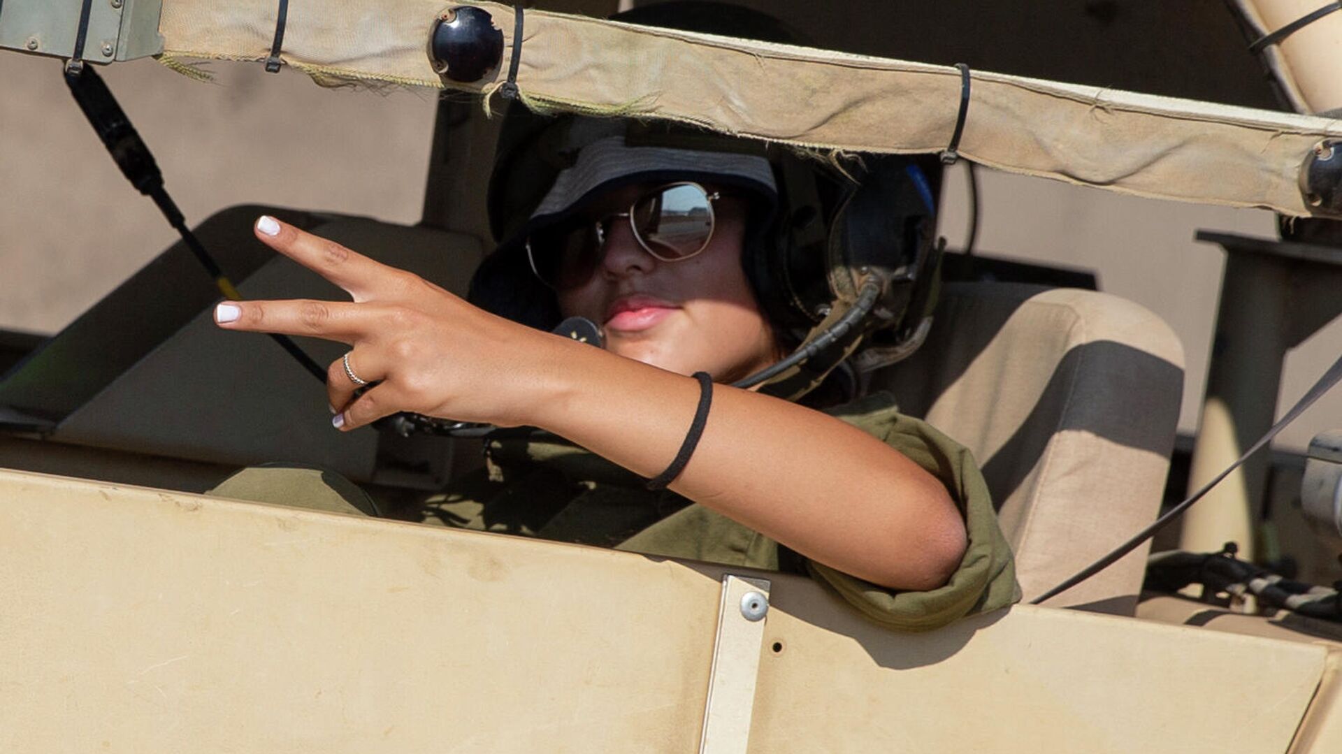 An Israeli female soldier flashes a victory sign while siting in a military vehicle during an exercise in the Israeli controlled Golan Heights near the border with Syria, Tuesday, Aug. 4, 2020.  - Sputnik International, 1920, 27.05.2022