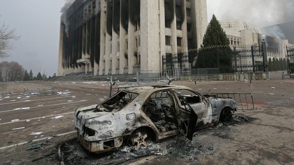 A burned car is seen in front of the mayor's office building which was torched during protests triggered by fuel price increase in Almaty, Kazakhstan January 6, 2022 - Sputnik International