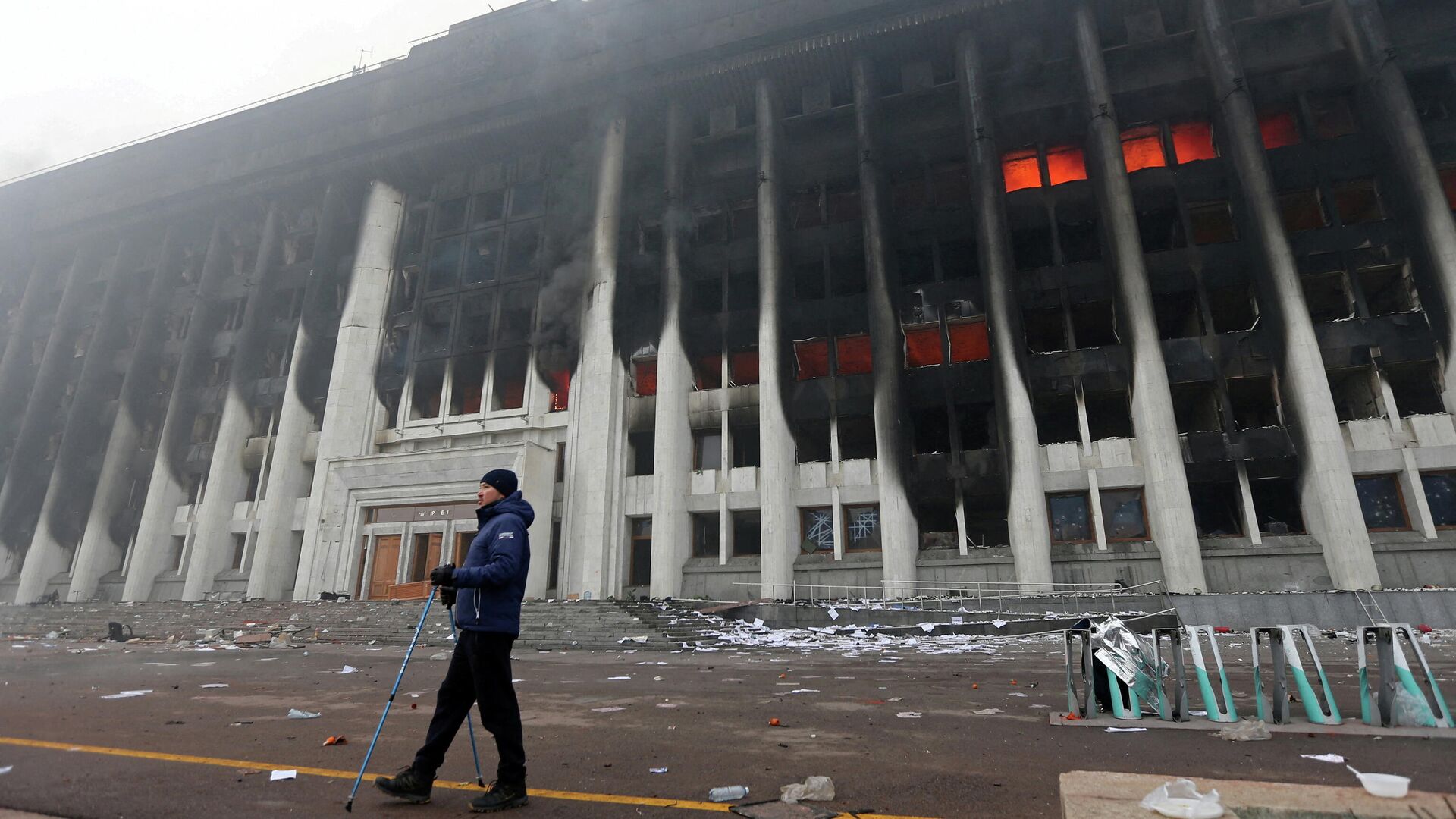 A man stands in front of the mayor's office building which was torched during protests triggered by fuel price increase in Almaty, Kazakhstan January 6, 2022 - Sputnik International, 1920, 14.01.2022