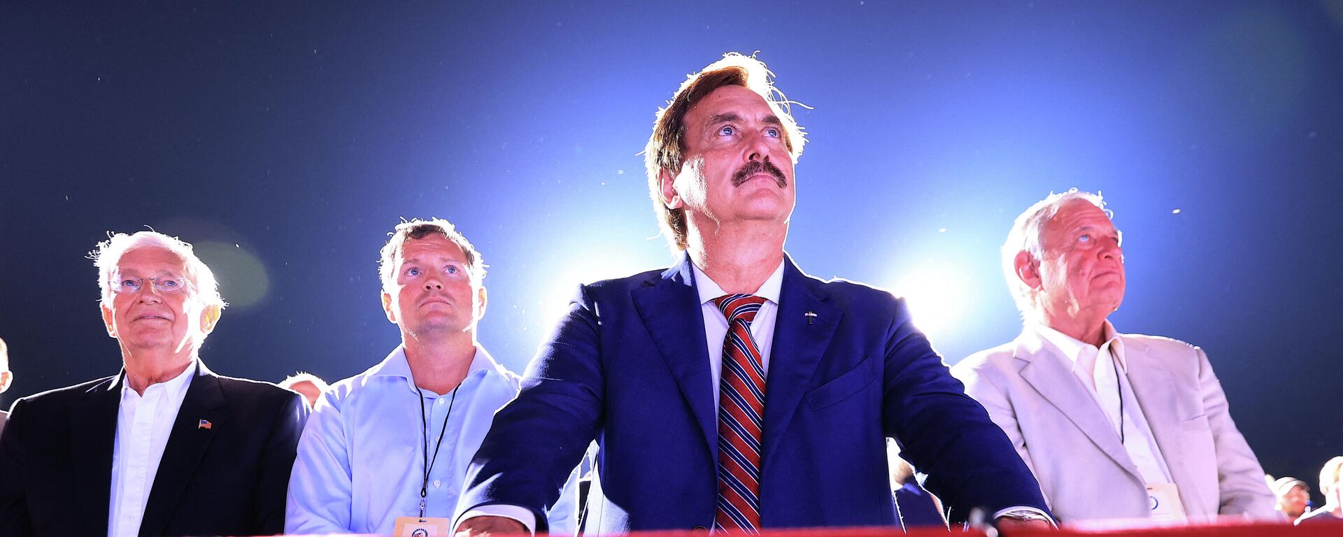 Founder and CEO of My Pillow, conservative political activist and conspiracy theorist Mike Lindell (C) listens to former U.S. President Donald Trump addresses supporters during a Save America rally at York Family Farms on August 21, 2021 in Cullman, Alabama. - Sputnik International, 1920, 06.01.2022