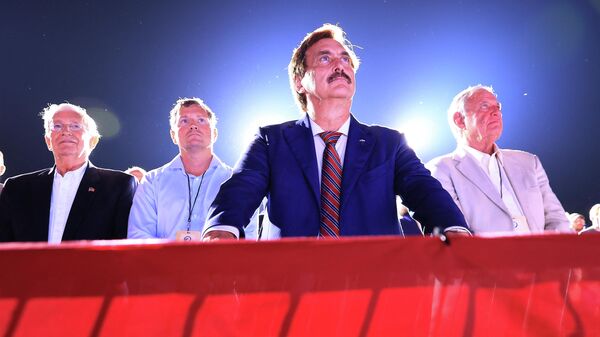 Founder and CEO of My Pillow, conservative political activist and conspiracy theorist Mike Lindell (C) listens to former U.S. President Donald Trump addresses supporters during a Save America rally at York Family Farms on August 21, 2021 in Cullman, Alabama. - Sputnik International