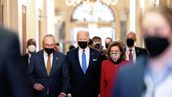 U.S. President Joe Biden joined by Senate Majority Leader Chuck Schumer (D-NY) and U.S. House Speaker Nancy Pelosi (D-CA) walks through the Hall of Columns before speaking during a ceremony on the first anniversary of the January 6, 2021 attack on the U.S. Capitol by supporters of former President Donald Trump in Washington, D.C., U.S., January 6, 2022 - Sputnik International