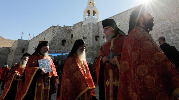 Members of clergy gather as Greek Orthodox Patriarch of Jerusalem Theophilos III arrives at the Church of the Nativity to celebrate Christmas according to the Eastern Orthodox calendar, in Bethlehem in the Israeli occupied West Bank, January 6, 2022 - Sputnik International