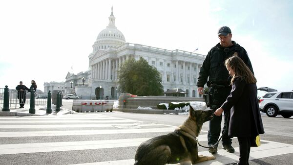 Chloe Chen, 5, of Fairfax, Virginia meets a security dog named Dante while offering snacks to a U.S. Capitol Police officer on the first anniversary of the January 6, 2021 attack on the Capitol by supporters of former U.S. President Donald Trump, on Capitol Hill in Washington, U.S., January 6, 2022. - Sputnik International