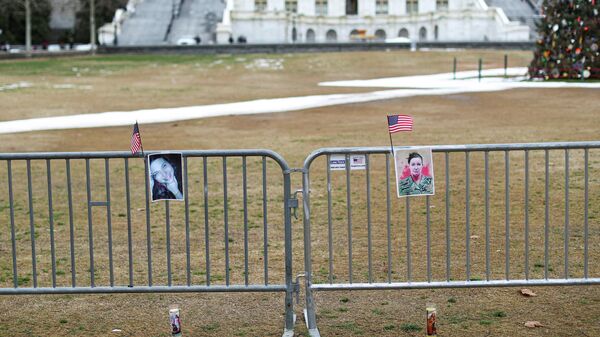 Portraits of Rosanne Boyland and of Ashli Babbitt who was shot dead during the January 6, 2021 attack on the U.S. Capitol, hang on a security fence on the first anniversary the event outside the Capitol, in Washington, D.C., U.S., January 6, 2022. - Sputnik International