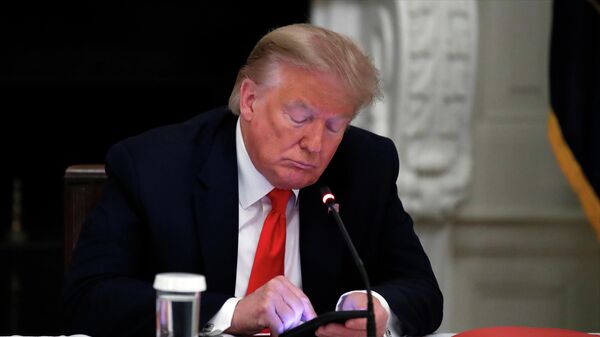  In this Thursday, June 18, 2020 file photo, President Donald Trump looks at his phone during a roundtable with governors on the reopening of America's small businesses, in the State Dining Room of the White House in Washington. - Sputnik International