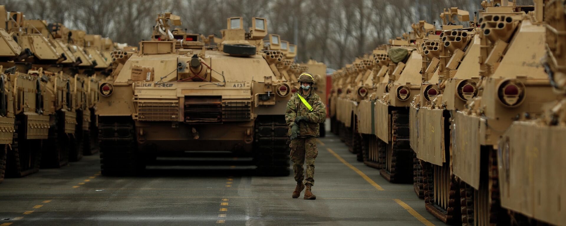 A U.S. soldier walks past parked armoured vehicles and tanks of the 1st Armored Brigade Combat Team and 1st Calvary Division, based out of Fort Hood, Texas, as they are unloaded at the port of Antwerp, Belgium, Monday, Nov. 16, 2020. The U.S. military vehicles are on their way to Eastern Europe to take part in the Atlantic Resolve military exercises, in which American troops train together with NATO partners to help ensure stability in Europe. - Sputnik International, 1920, 26.01.2022