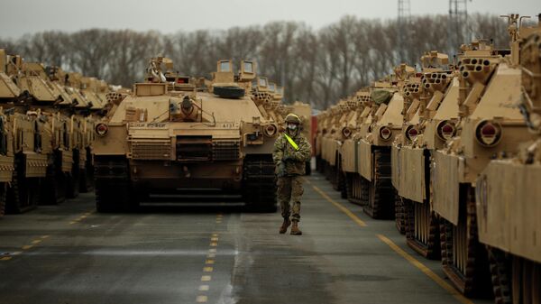 A U.S. soldier walks past parked armoured vehicles and tanks of the 1st Armored Brigade Combat Team and 1st Calvary Division, based out of Fort Hood, Texas. File photo. - Sputnik International