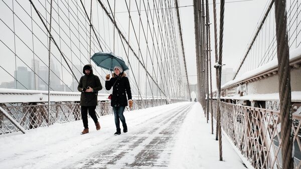 People walk through the snow on the Brooklyn Bridge in Manhattan on January 07, 2022 in New York City. New York City and much of the tri-state region received over four inches of snow in what is the first significant snow accumulation of the season. - Sputnik International