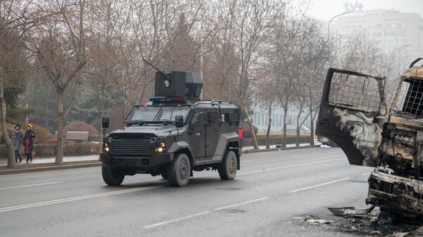 A military vehicle moves along a street in central Almaty on 7 January 2022, after violence that erupted following protests over hikes in fuel prices. - Sputnik International