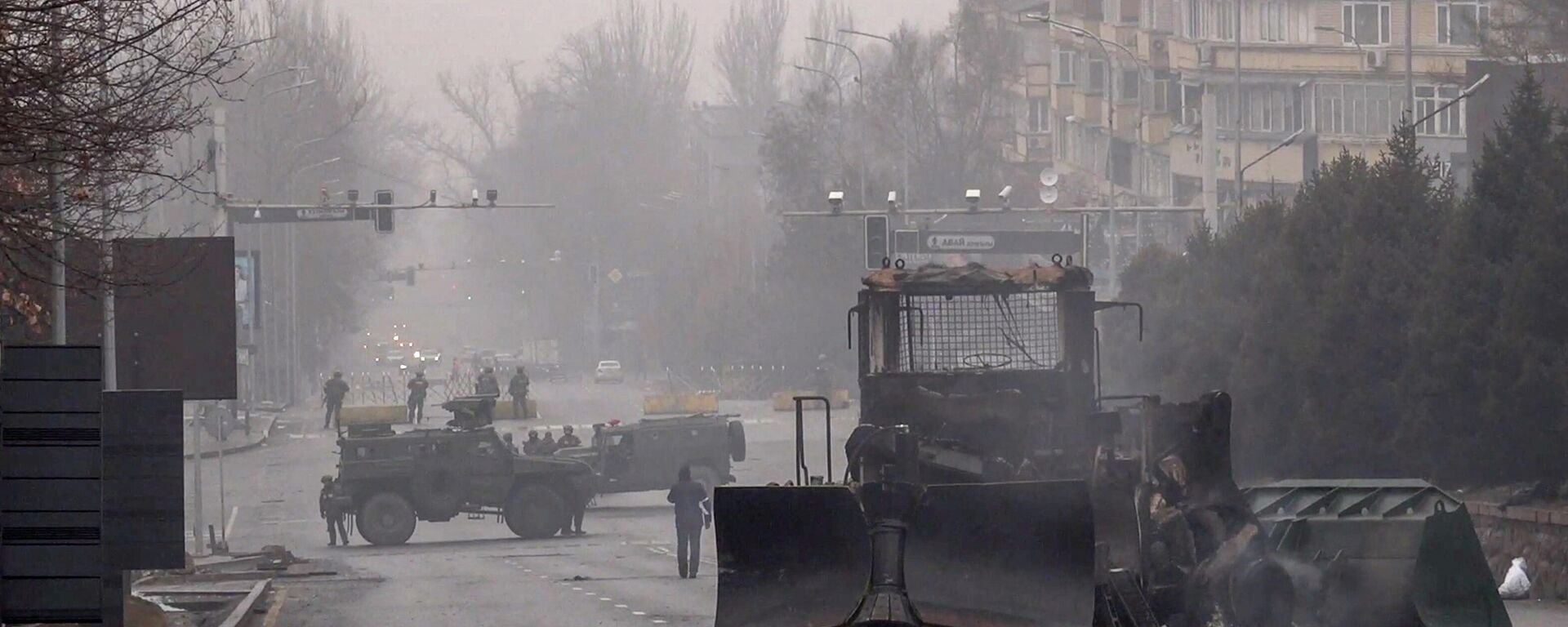 Servicemen and their military vehicles block a street in central Almaty on January 7, 2022, after violence that erupted following protests over hikes in fuel prices - Sputnik International, 1920, 09.01.2022