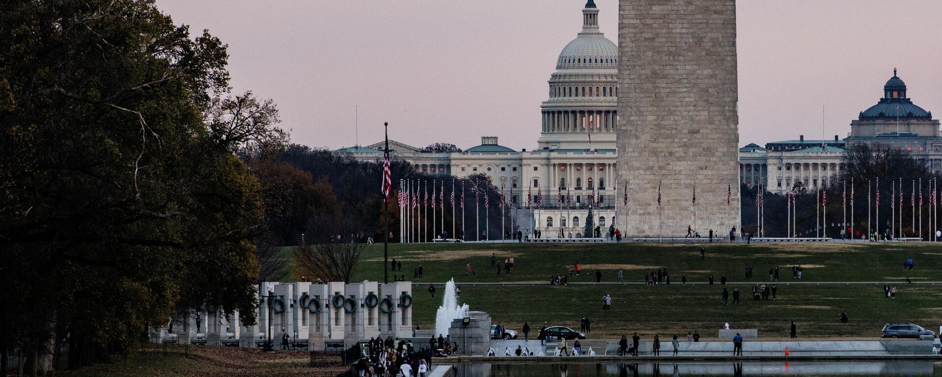 The U.S. Capitol Building is seen past the Washington Monument as people walk around the Reflecting Pool on the National Mall as the sun sets on November 28, 2021 in Washington, DC. President Biden returned to Washington after spending the Thanksgiving Holiday with family in Nantucket and immediately met with members of his medical team to discuss the newly discovered Omicron variant of the coronavirus. - Sputnik International, 1920, 17.01.2022