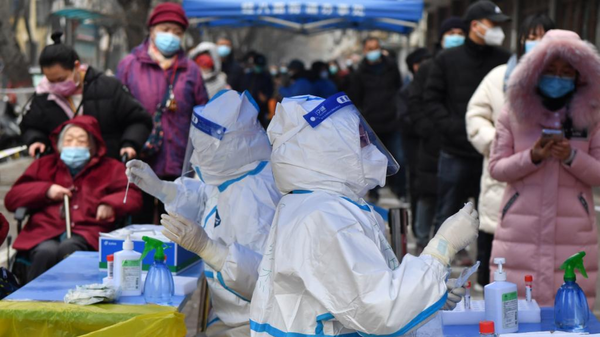 Medical workers take swab samples for COVID-19 tests at a testing site in Zhengzhou, central China's Henan Province, Jan. 7, 2022. - Sputnik International