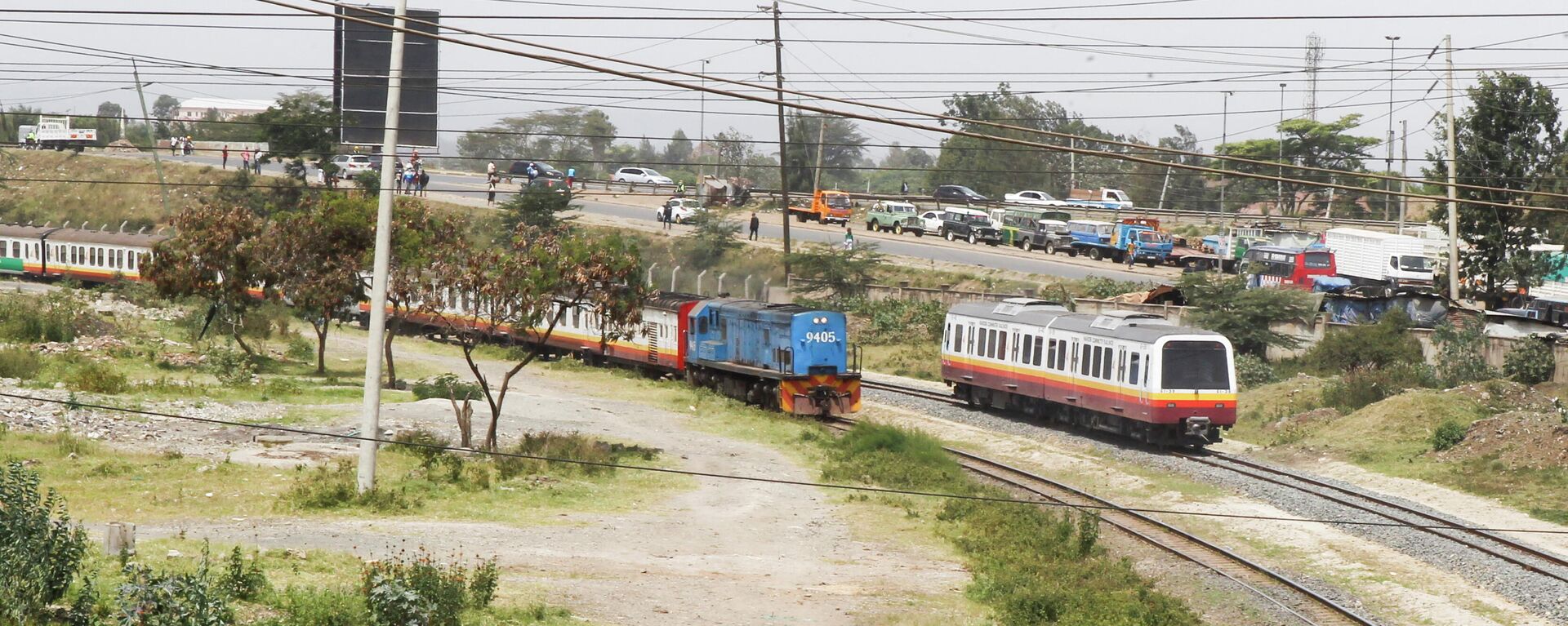 A Diesel Mobile Unit (DMU) train of the Nairobi Commuter Rail Service (NCRS) operated by the Kenya Railway Corporation (KRC) from Embakasi to Nairobi is seen near the old generation locomotive engine train as it rides past Electricity power lines near the Donholm station in Nairobi, Kenya January 11, 2022. - Sputnik International, 1920, 11.01.2022