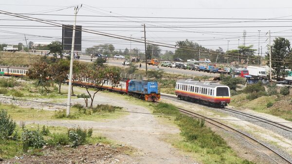 A Diesel Mobile Unit (DMU) train of the Nairobi Commuter Rail Service (NCRS) operated by the Kenya Railway Corporation (KRC) from Embakasi to Nairobi is seen near the old generation locomotive engine train as it rides past Electricity power lines near the Donholm station in Nairobi, Kenya January 11, 2022. - Sputnik International
