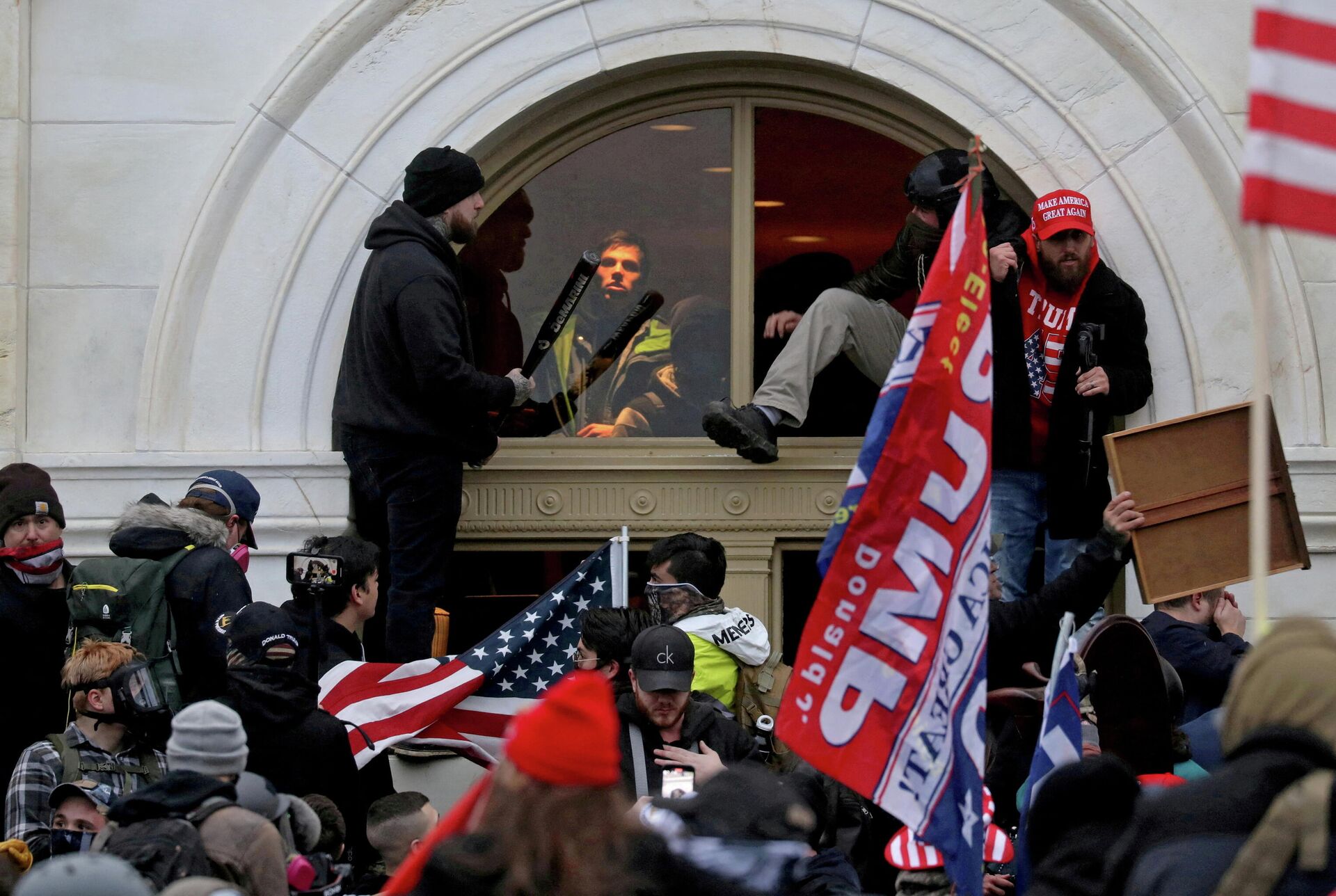 A mob of supporters of then-U.S. President Donald Trump climb through a window they broke as they storm the U.S. Capitol Building in Washington, U.S., January 6, 2021 - Sputnik International, 1920, 15.01.2022