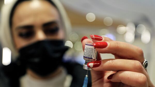 A health worker prepares a dose of Pfizer-BioNTech's coronavirus disease (COVID-19) vaccine as the COVID-19 vaccination campaign continues amid talks of a fourth dose for high-risk groups including those over the age of 60, in Malcha shopping mall, Jerusalem, December 22, 2021 - Sputnik International