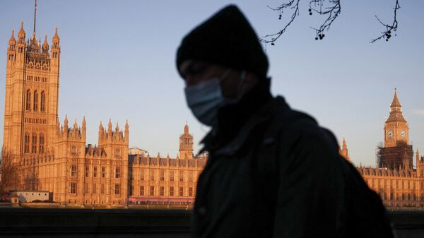 The Houses of Parliament can be seen as a person walks along the South Bank of the River Thames during sunrise, in London - Sputnik International