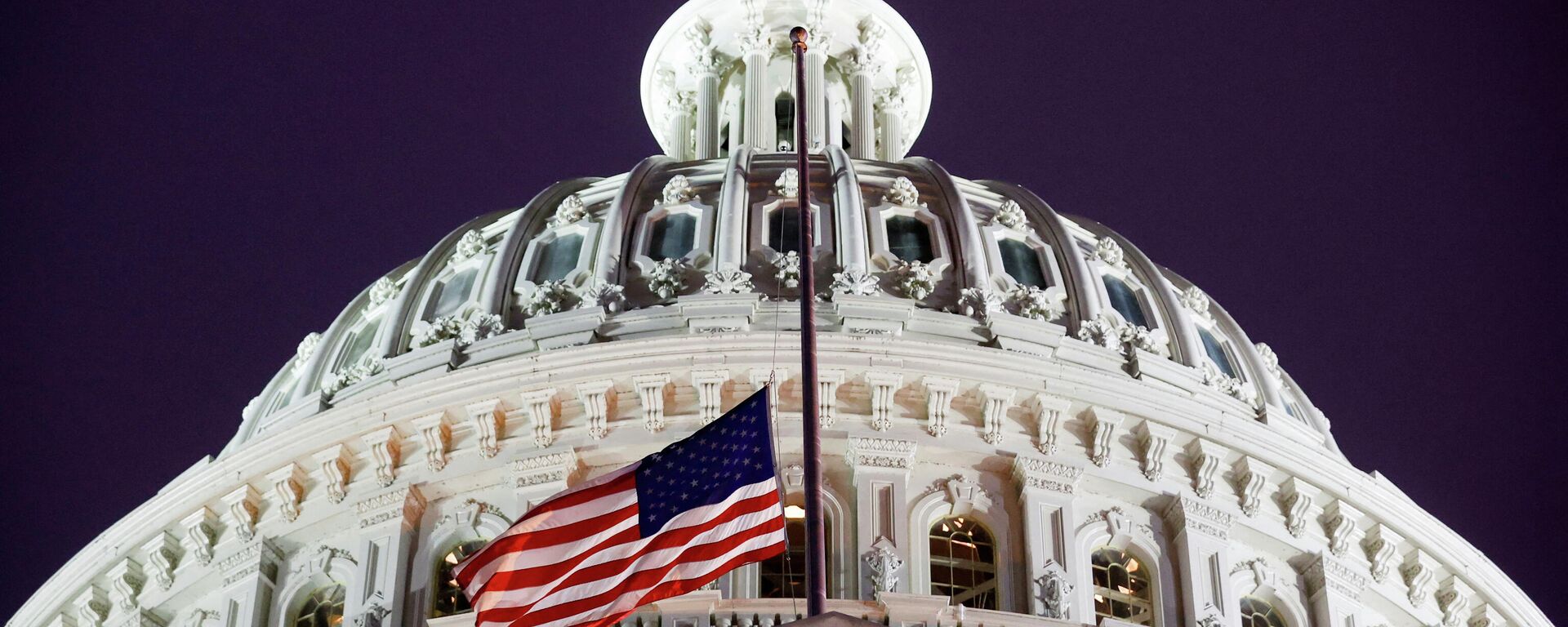 A flag of the United States is seen at halfstaff on the U.S. Capitol building during a prayer vigil in observance of the first anniversary of the January 6, 2021 attack on the Capitol by supporters of former President Donald Trump, on Capitol Hill in Washington, U.S., January 6, 2022. REUTERS/Jonathan Ernst - Sputnik International, 1920, 13.01.2022