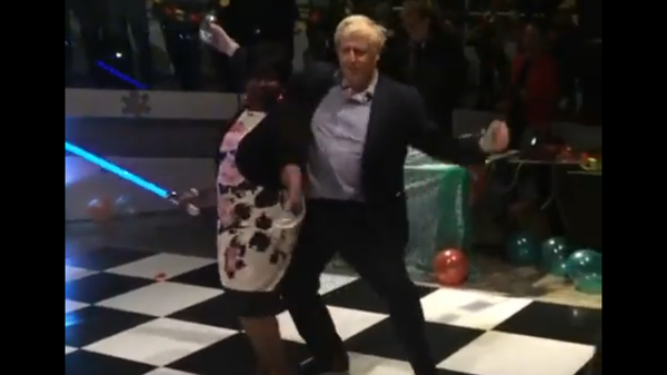 Screenshot from a video showing Boris Johnson dancing with a woman holding a lightsaber - Sputnik International