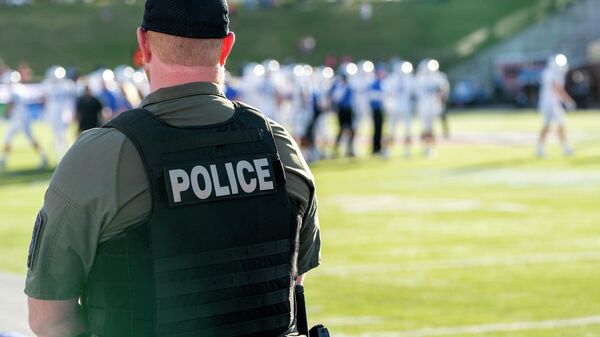 A police officer stands on the sidelines during the First Responder Bowl NCAA college football game between Air Force and Louisville Tuesday, Dec. 28, 2021, in Dallas. - Sputnik International