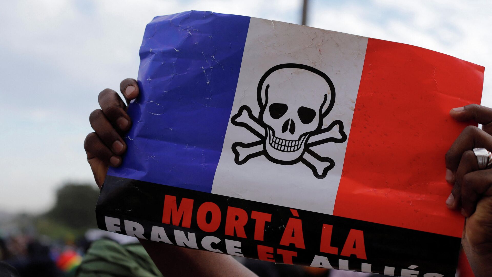 A supporter holds a flag of France, with the drawing of a skull on it, as he participates in a demonstration called by Mali's transitional government after ECOWAS (Economic Community of West African States) imposed sanctions in Bamako, Mali, January 14, 2022 - Sputnik International, 1920, 16.01.2022