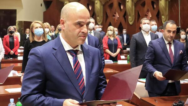 Dimitar Kovacevski, the new North Macedonia prime minister, takes an oath after the lawmakers voted for the new government on a session of parliament in Skopje, North Macedonia, late Sunday, Jan. 16, 2022 - Sputnik International
