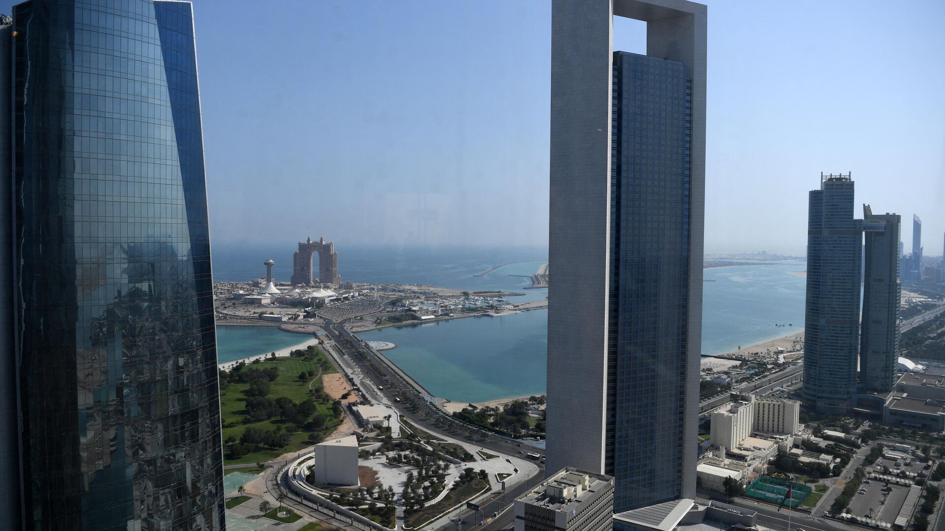 A general view shows the sea front promenade in the Emirati capital Abu Dhabi with the ADNOC headquarters (Abu Dhabi National Oil Company) office complex (C) in the foreground on May 29, 2019. - Sputnik International, 1920, 23.01.2022